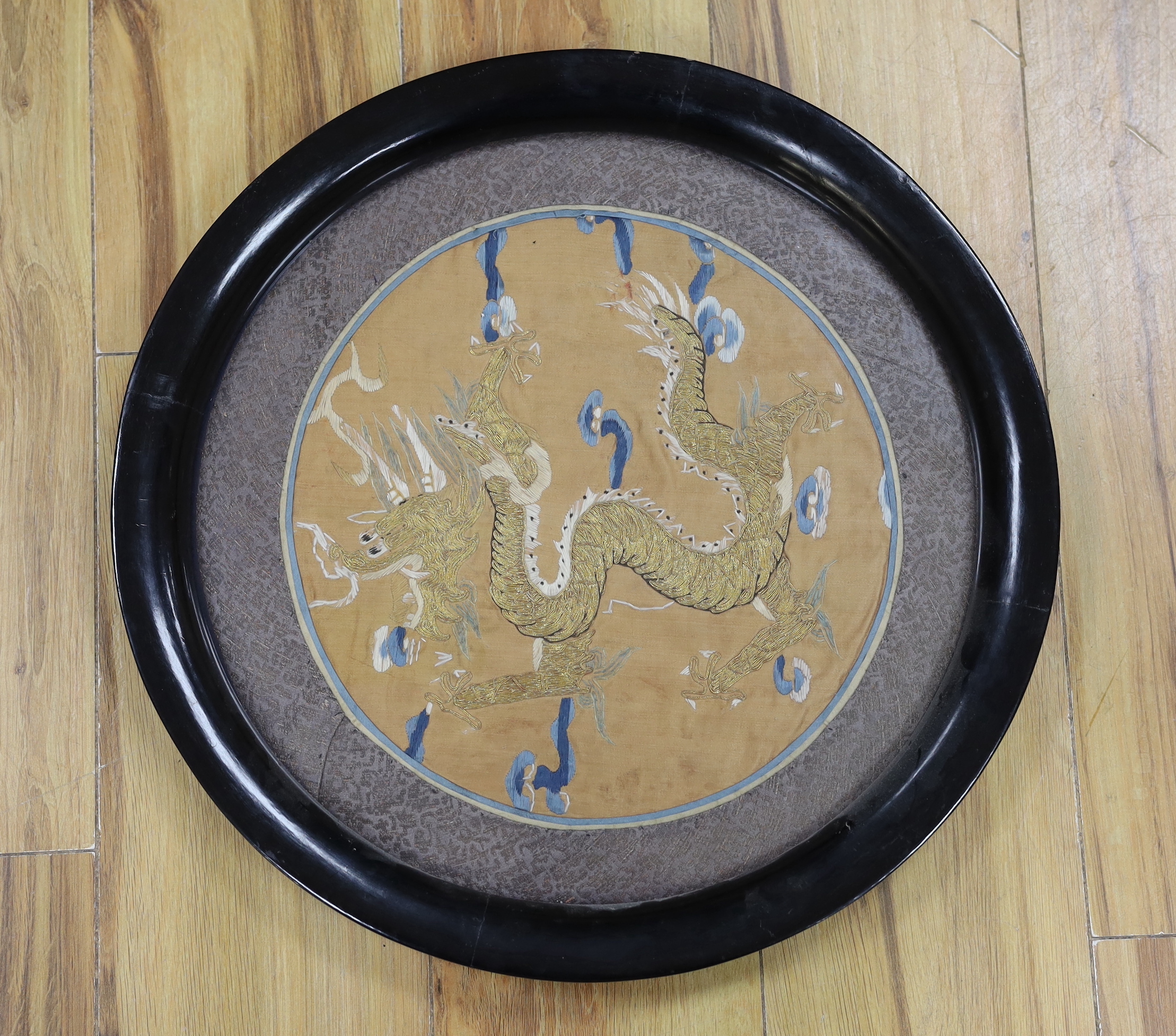 A Chinese circular ‘dragon’ embroidery, embroidered on silk in gold thread, slightly couched, framed 38cm diameter not including frame